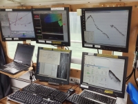 Photograph of six computer monitors displaying sonar data.