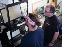 Photograph of Peter Lawton and his student watching a live feed of video from the seabed.