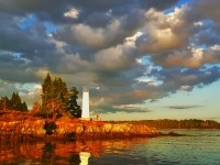 Photo du phare de la pointe Deer Point contre un ciel gris nuageux.